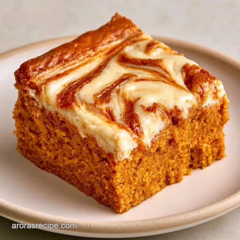 Neatly stacked orange and white dessert squares on a ceramic plate with a dusting of cinnamon and a linen napkin.